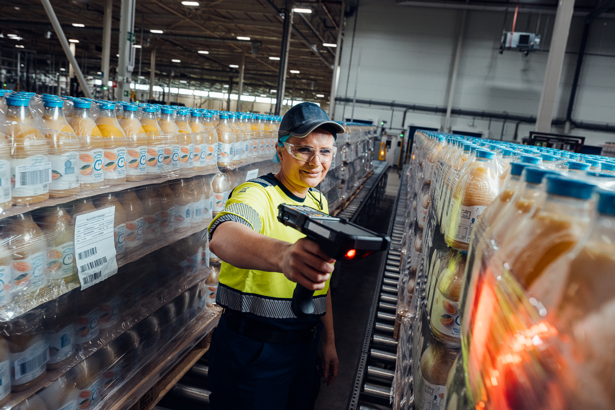 A worker scans juice bottles in a factory.